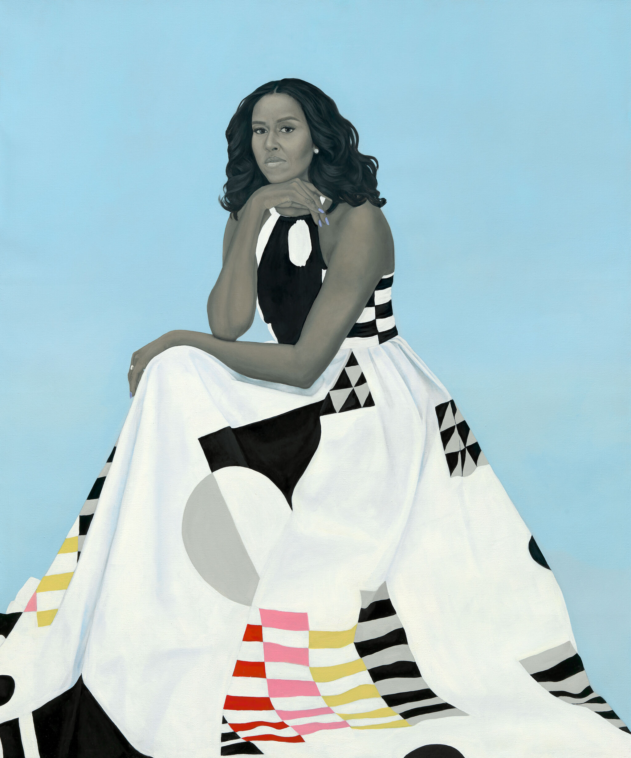 A woman in a patterned dress sits against a light blue background, resting her chin on her hand, with a thoughtful expression.